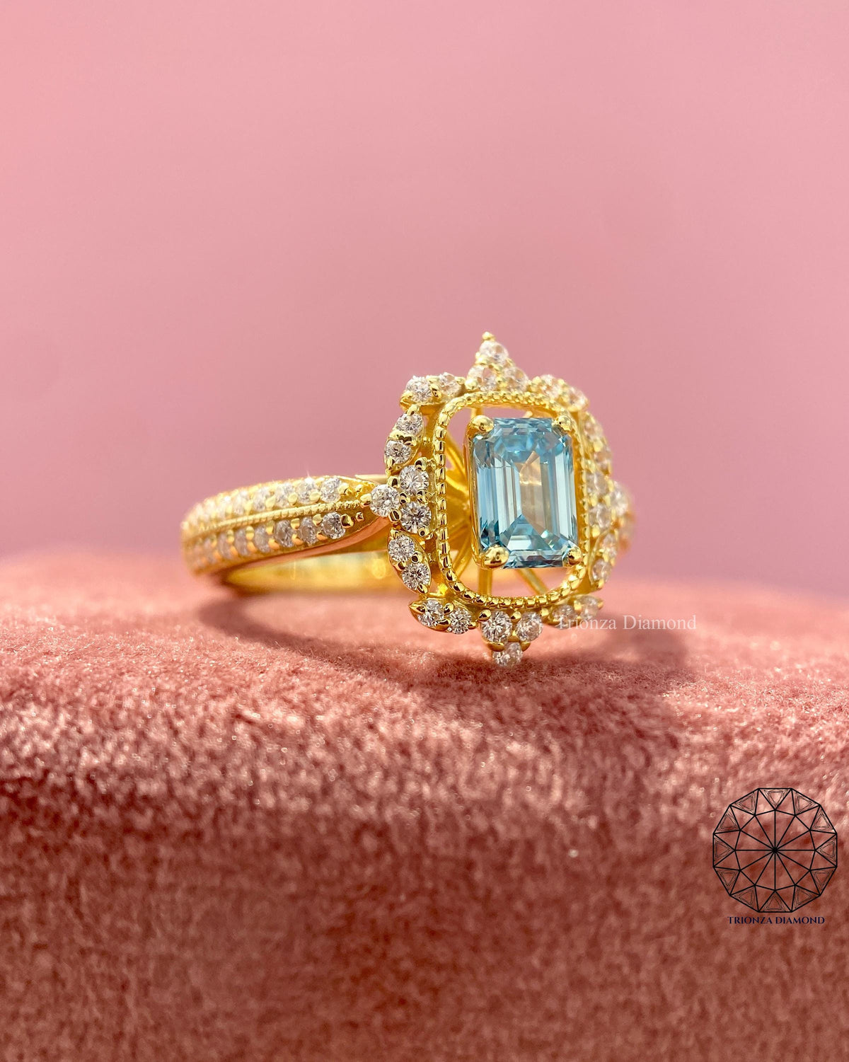 Gold emerald cut ring showcasing the halo setting surrounding the center diamond