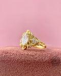 18k solid gold engagement ring showcasing intricate leaf detailing around the marquise stone