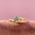 Toi et moi engagement ring featuring a marquise pink diamond and an oval blue diamond in 14k gold