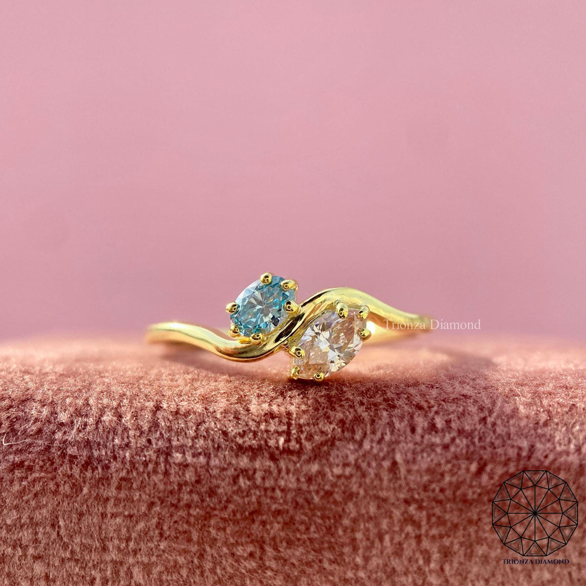 Toi et moi engagement ring featuring a marquise pink diamond and an oval blue diamond in 14k gold