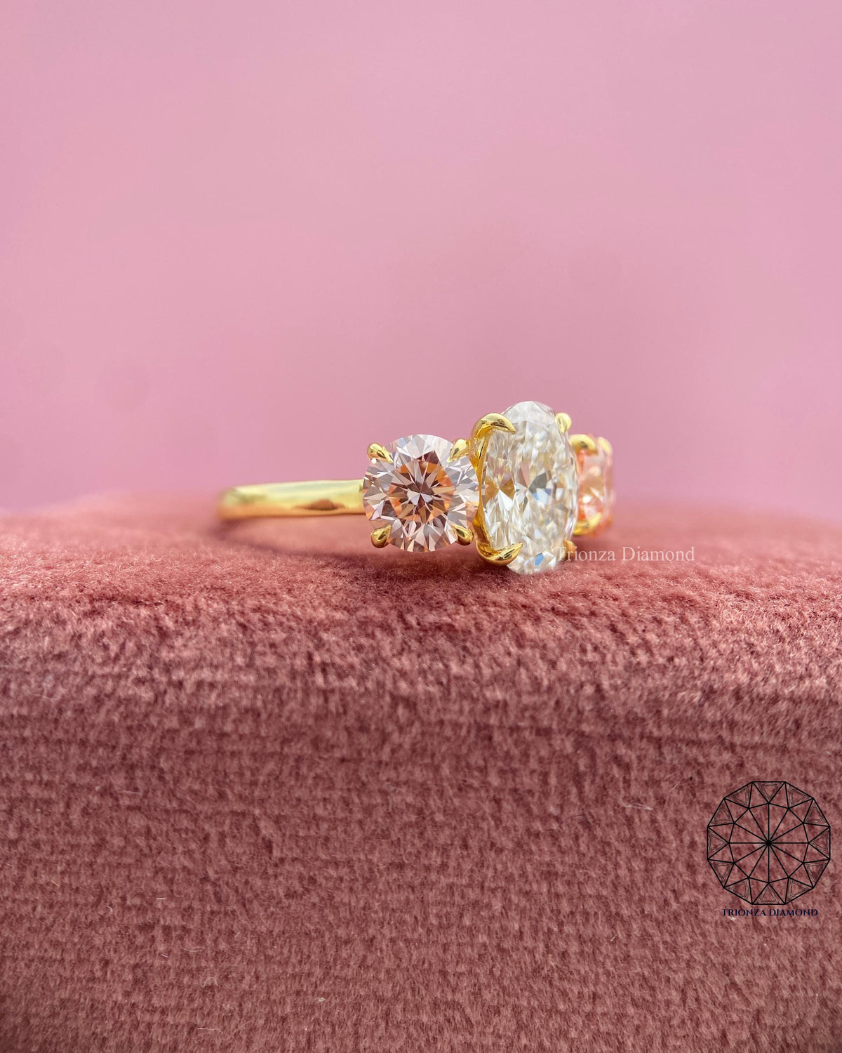Trilogy ring for her displayed to show the oval diamond and side round pink diamonds in detail