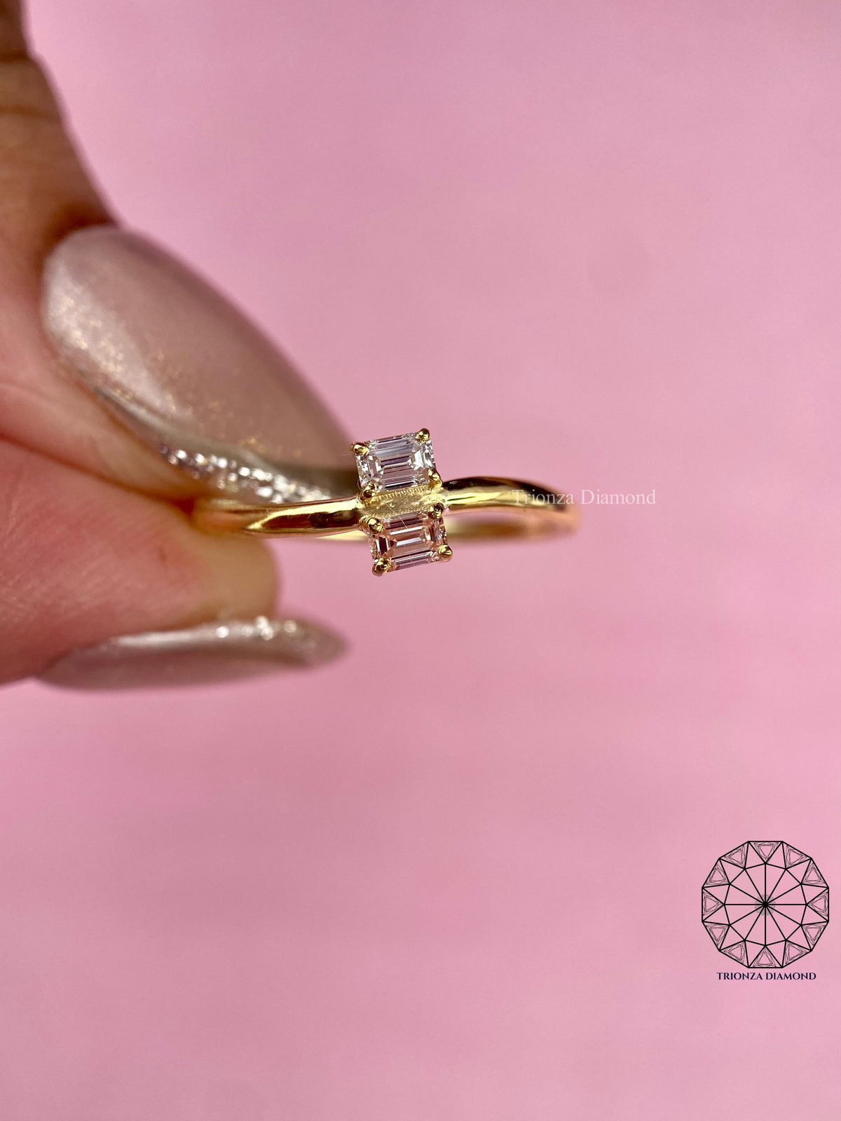 Emerald cut pink diamond paired with a white diamond in a dainty anniversary ring