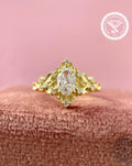 Vintage oval diamond engagement ring featuring a yellow gold leaf and cluster design