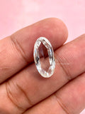Elongated oval rose cut lab grown diamond displayed to show its flat cut facets and vintage style