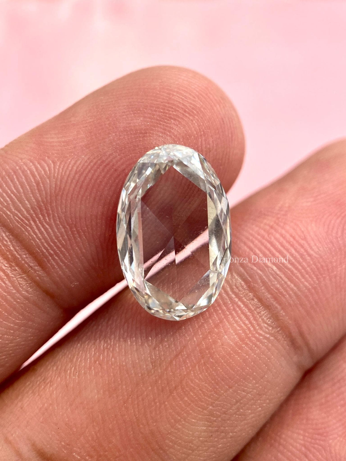 Oval rose cut lab grown diamond displayed to show its unique faceted rose cut pattern
