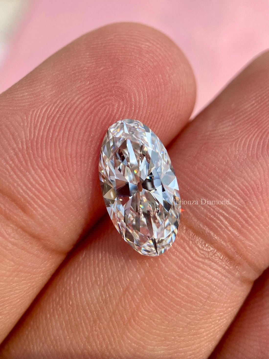 Elongated oval cut lab grown diamond displayed to show its brilliant faceted surface