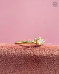 Close-up of the dainty prong set teardrop diamond with round accent stones