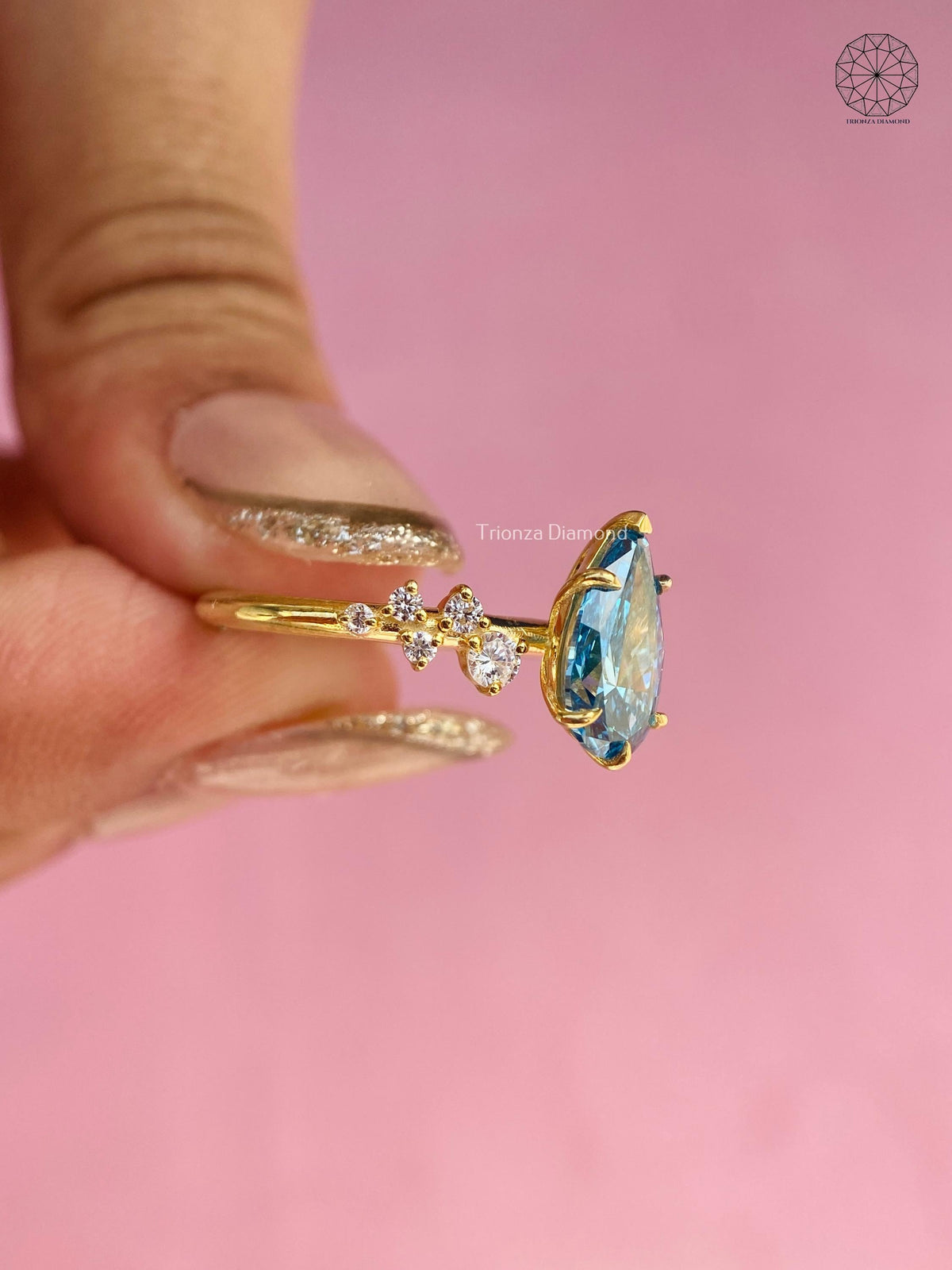 Blue pear ring displayed in a jewelry box to show its statement bridal styling