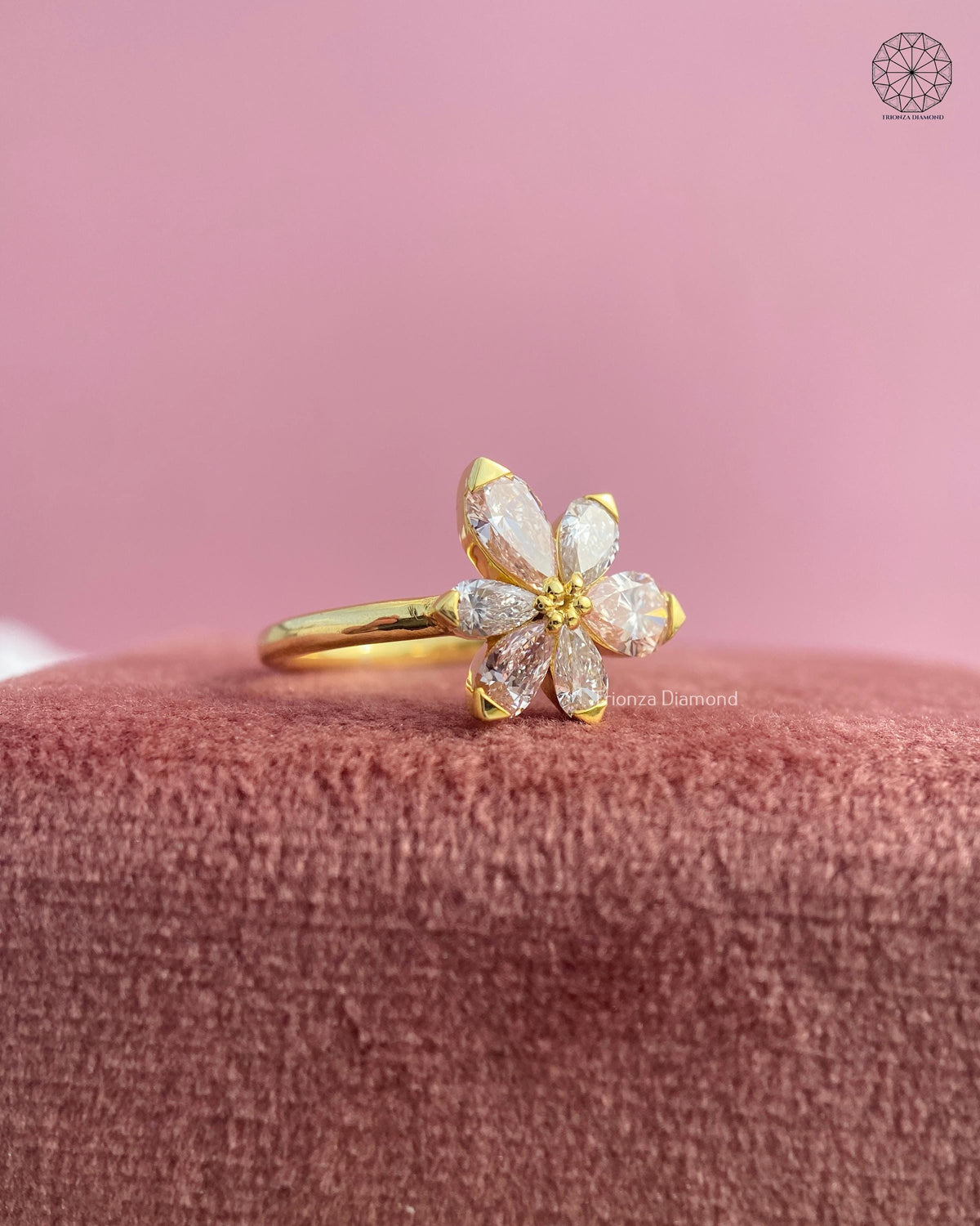 Pear diamond ring displayed to highlight the modern floral design and yellow gold band
