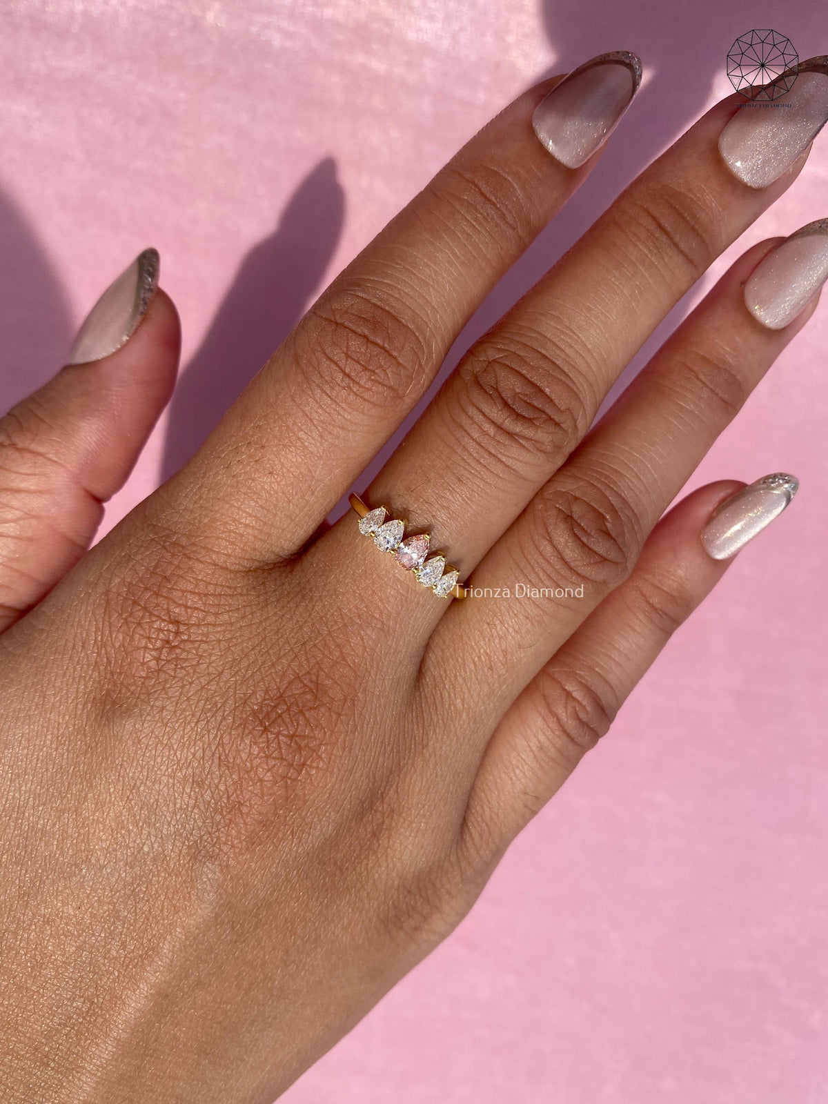 Close-up detail of the side pear diamonds set within the yellow gold crown band