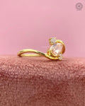 Teardrop shaped orange diamond ring displayed to highlight its three stone bypass design