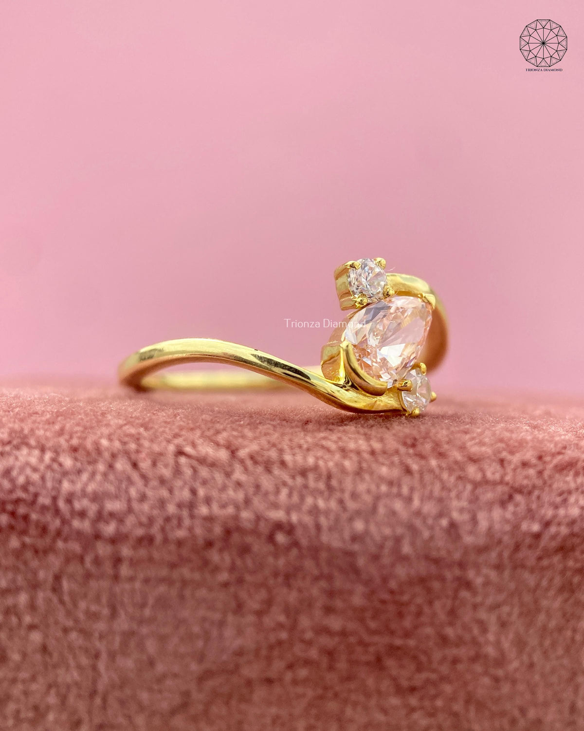 Teardrop shaped orange diamond ring displayed to highlight its three stone bypass design
