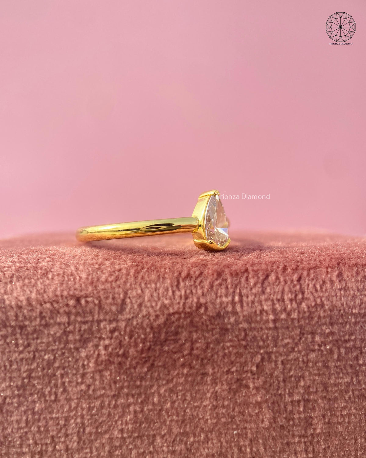 Yellow gold slim band ring featuring a teardrop shaped lab grown diamond