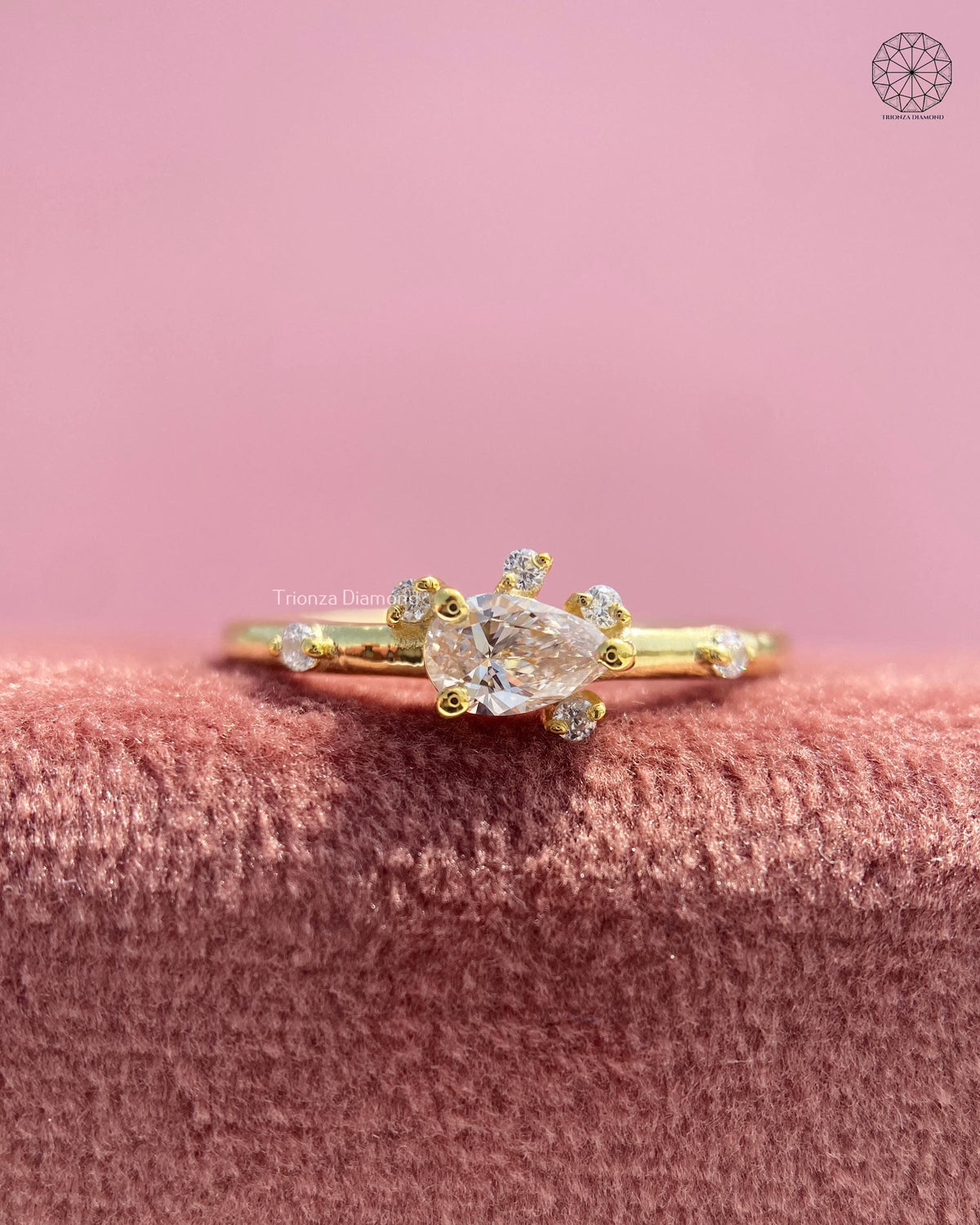Sideways pear diamond ring featuring a pink lab grown diamond set in 14K yellow gold