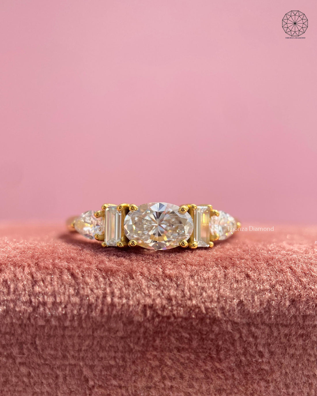 Lab grown diamond engagement ring featuring an oval center stone with pear and baguette side stones