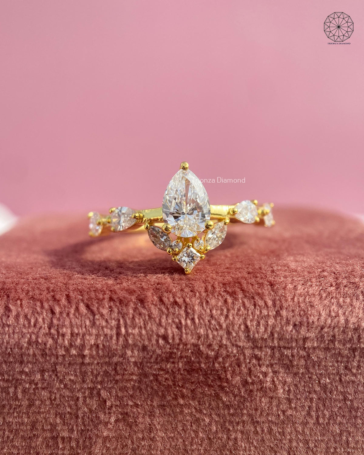 Pear cut lab grown diamond engagement ring featuring a yellow gold floral cluster design