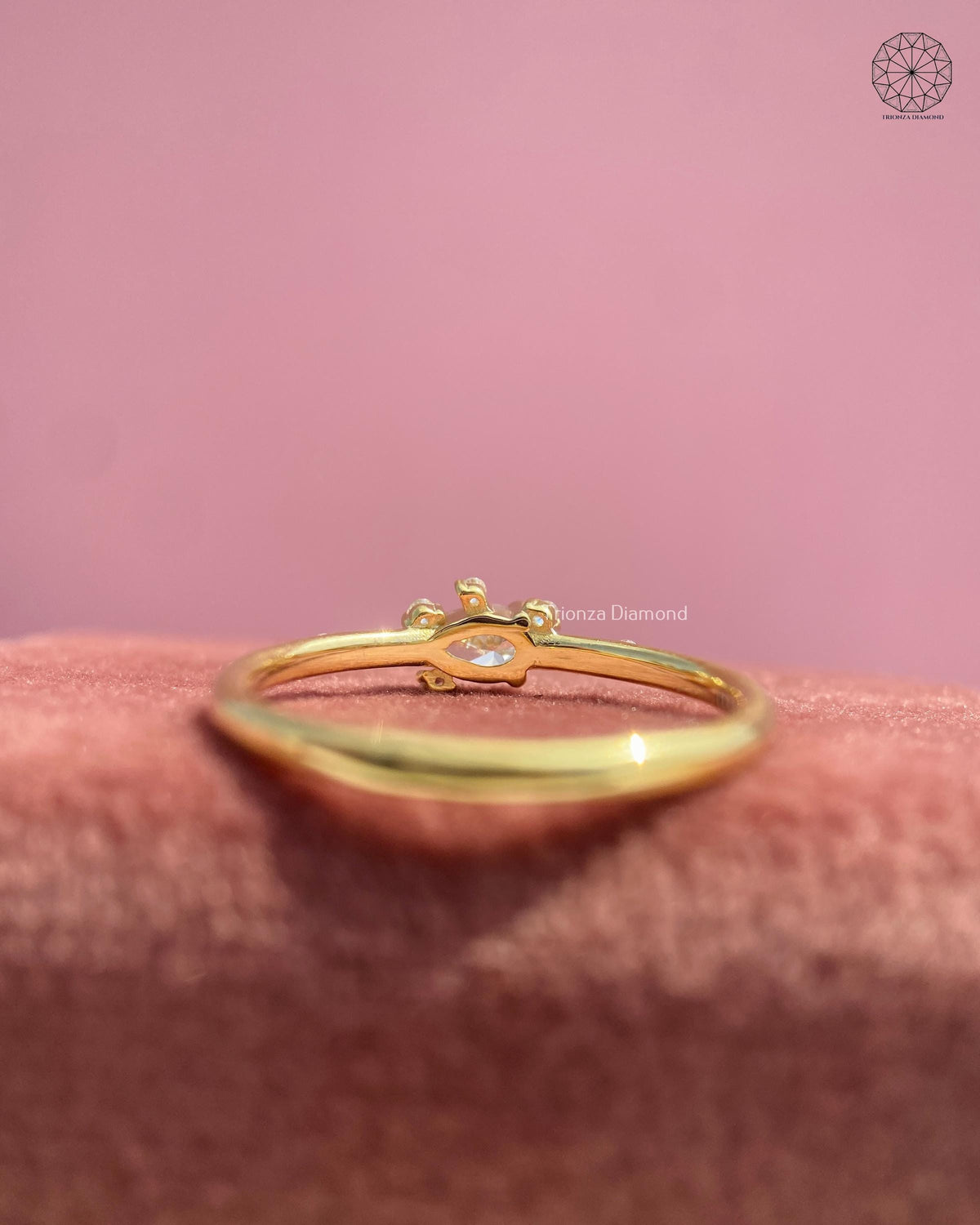 Slim gold band pinky ring showcasing an east west pear cut pink diamond