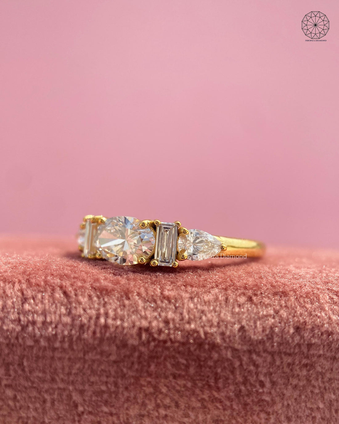 Lab grown diamond engagement ring featuring an oval center stone with pear and baguette side stones