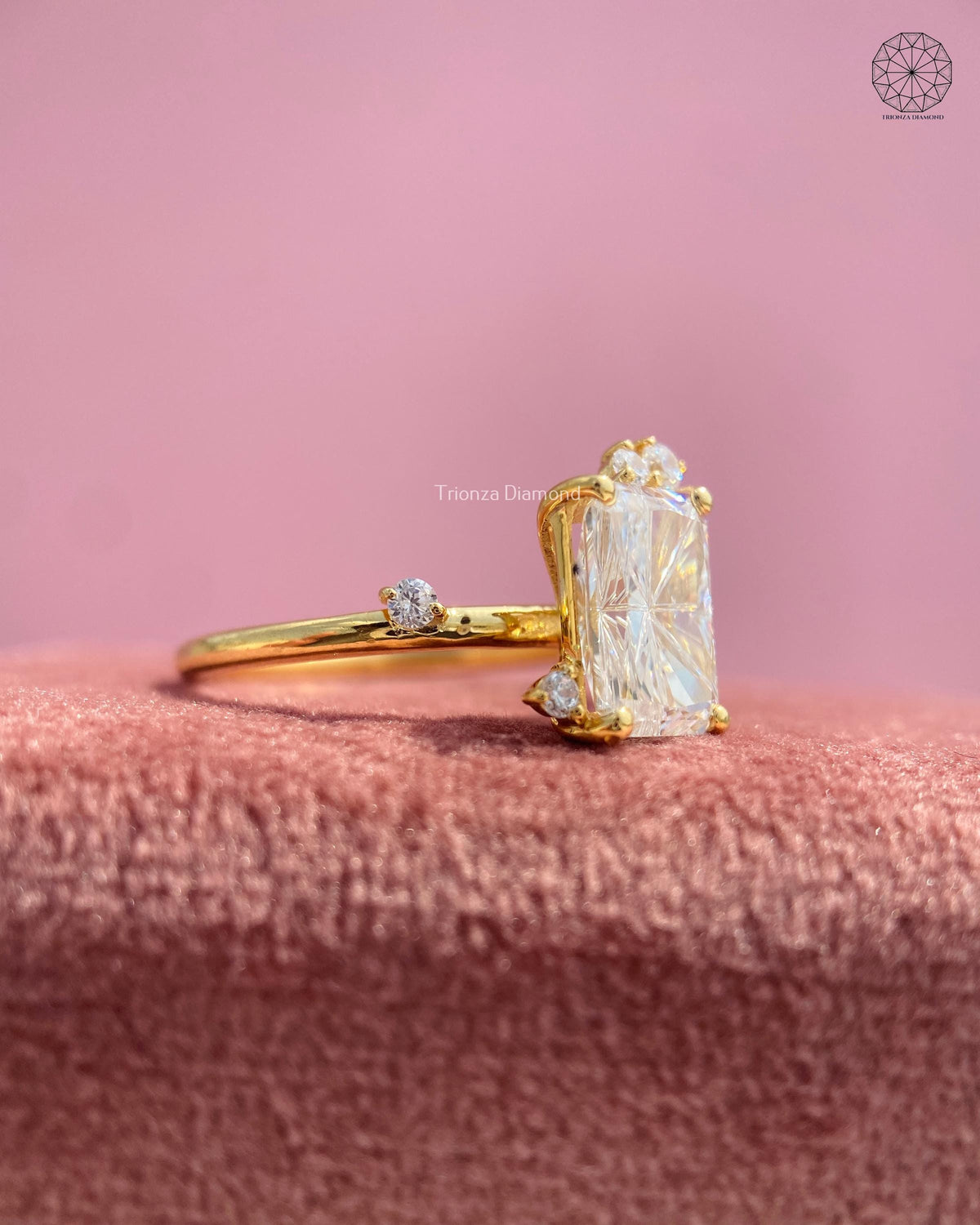 Yellow gold solitaire ring featuring a rectangular radiant diamond with sprig-style accents