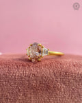 Close-up of the oval champagne diamond with trapezoid cut side diamonds in prong settings