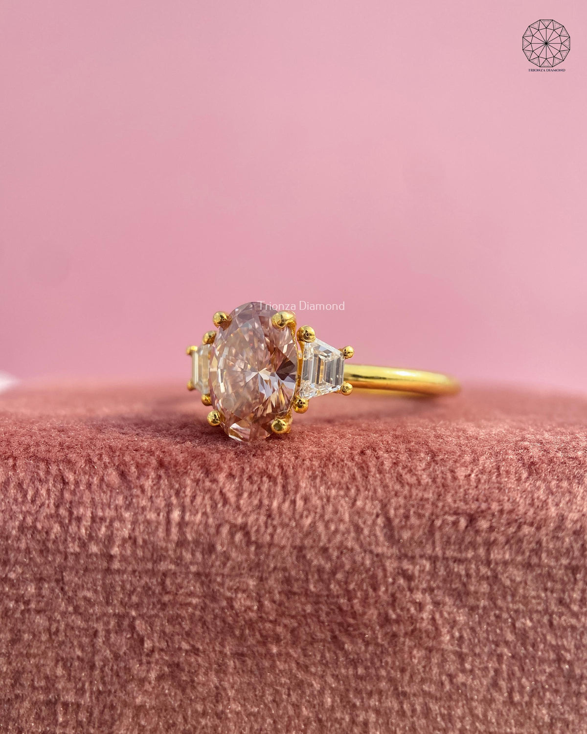 Close-up of the oval champagne diamond with trapezoid cut side diamonds in prong settings