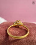 Prong set oval brilliant ring showing the plain gold band and side stone placement