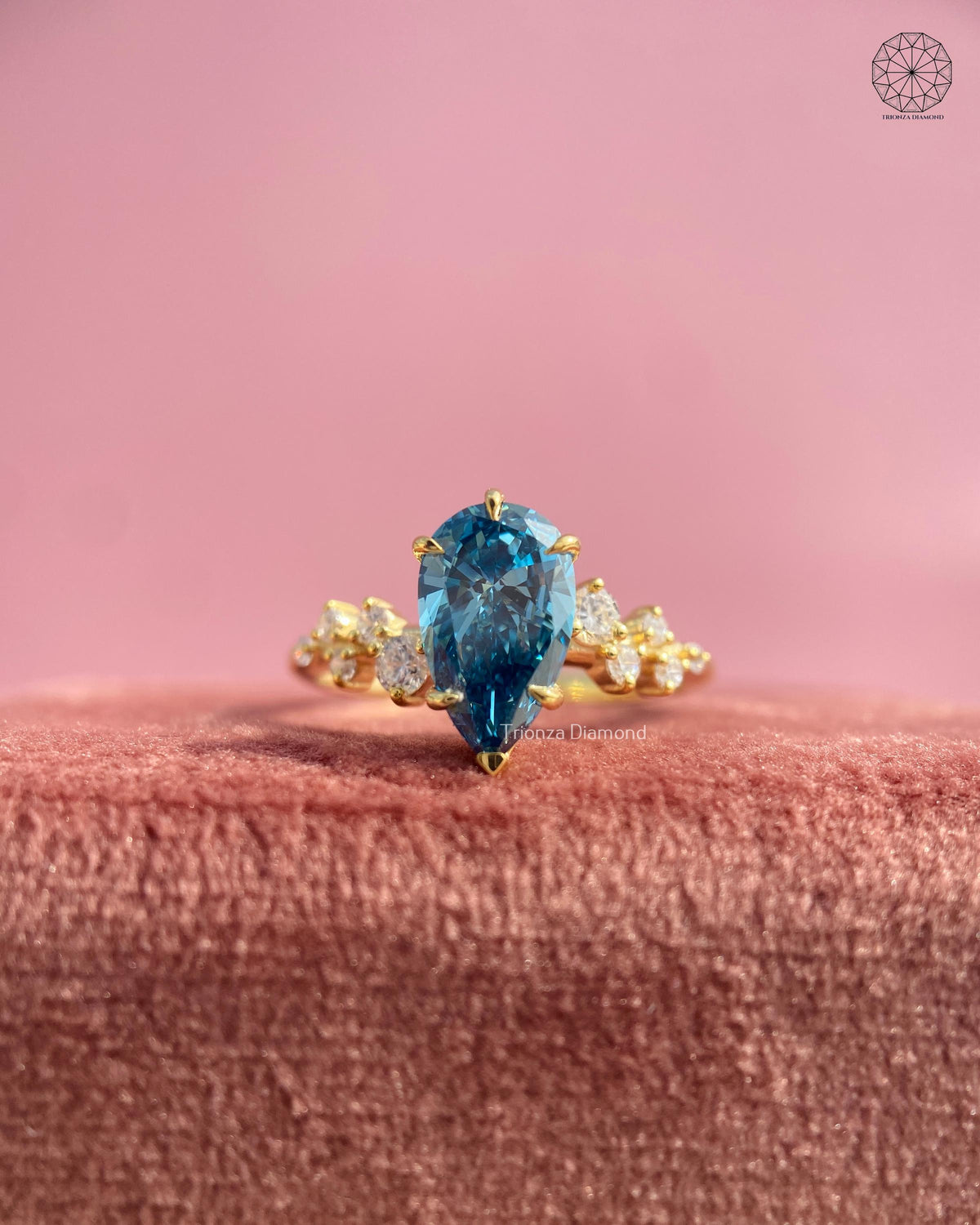 Close-up of the cluster shoulder detailing surrounding the pear cut blue diamond ring