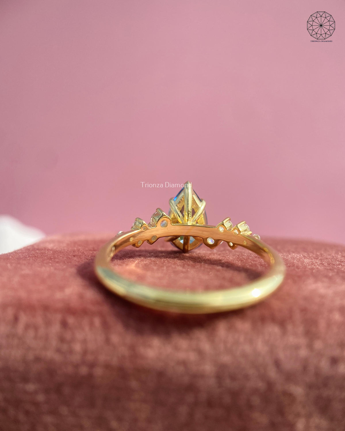 Top view of the yellow gold ring highlighting the pear cut blue gemstone center stone