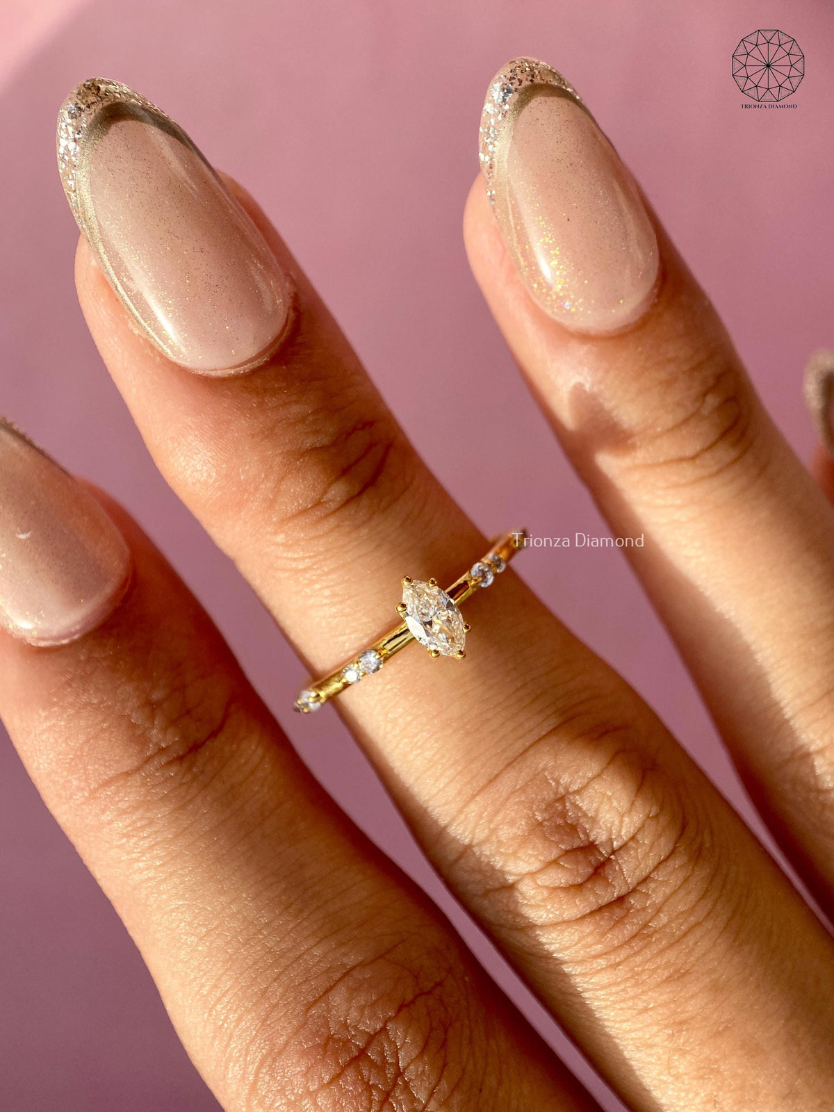 Yellow gold engagement ring displayed to show the slim band and accent cluster details