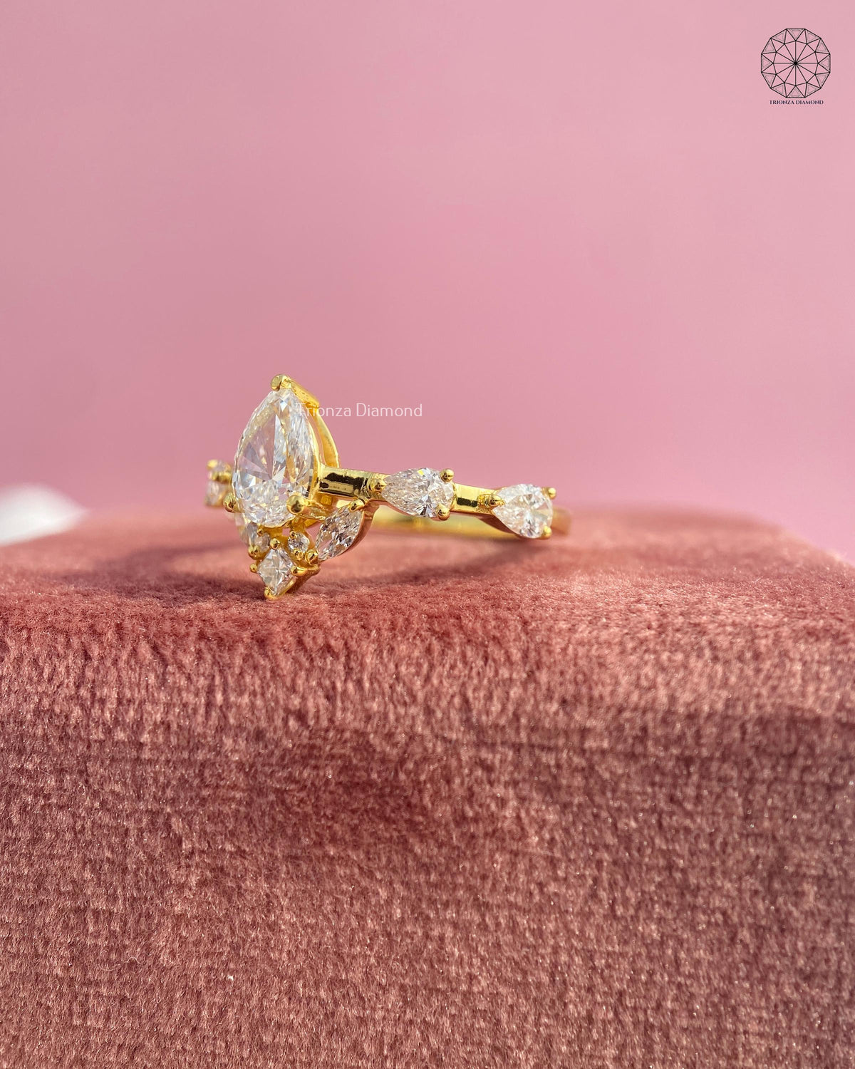Close-up of the prong set pear diamond showing side marquise and princess cut stones