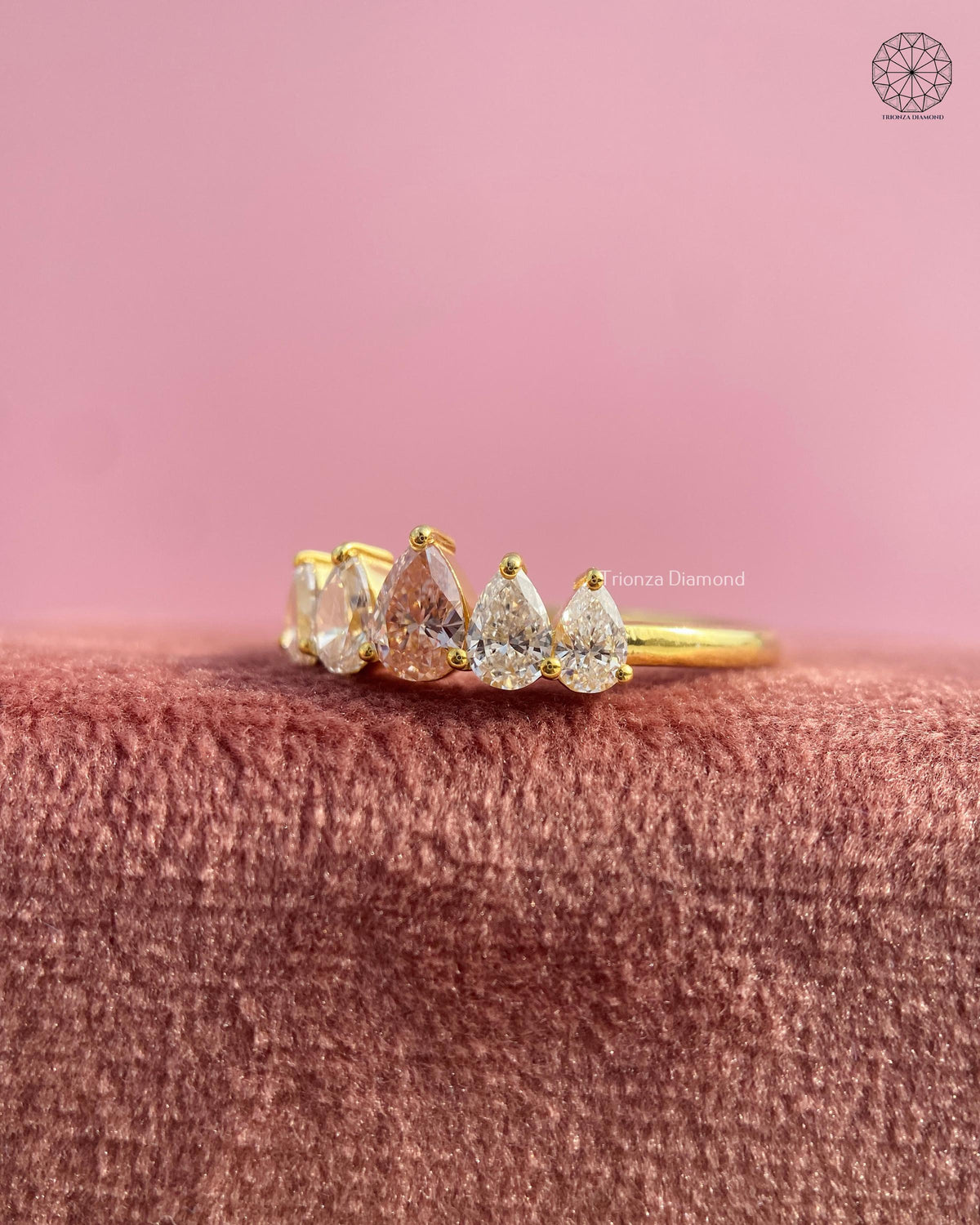 Yellow gold wedding band showcasing the curved tiara crown silhouette with pear cut stones