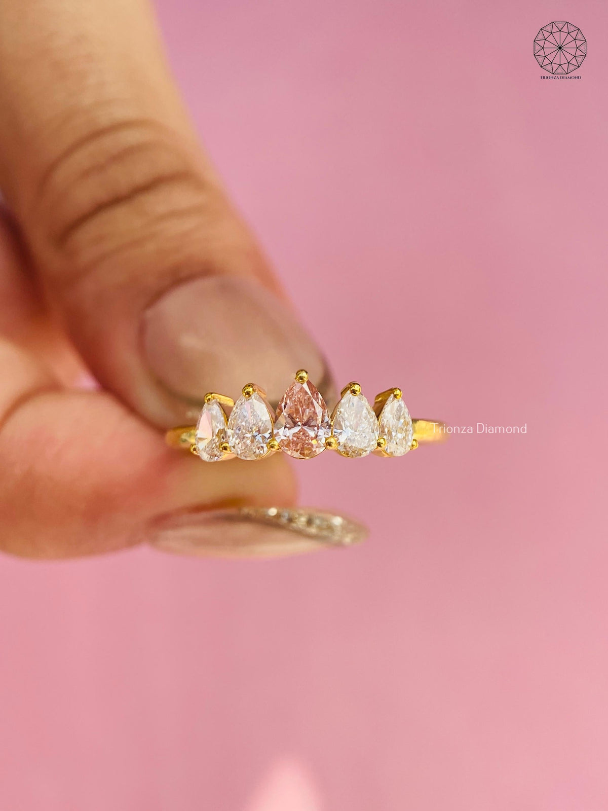 Woman wearing the pear diamond stackable ring alongside other wedding bands on her hand
