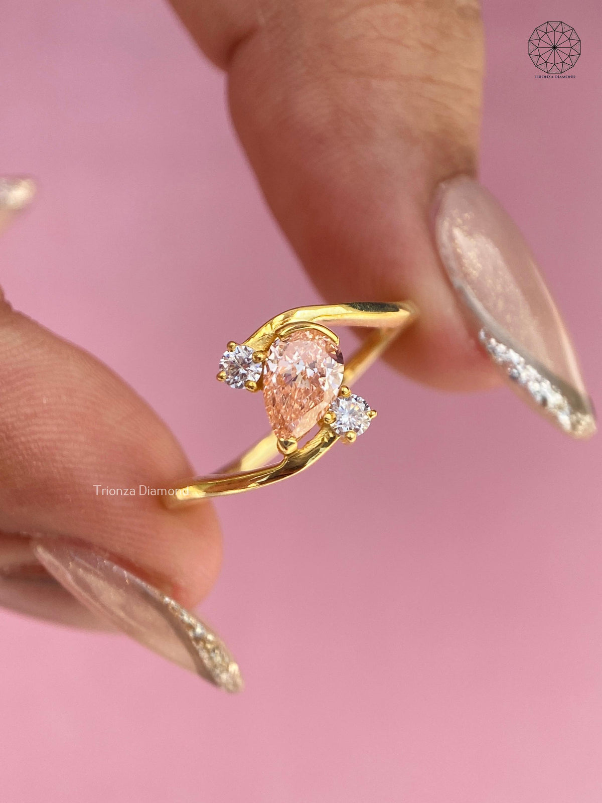 Close-up of the pear cut diamond showing its orange color and excellent polish and symmetry