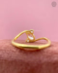 Angled view of the yellow gold swirl ring showing the pear diamond and round side stones