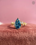 Close-up of the prong set pear shaped blue diamond in the 14K yellow gold setting