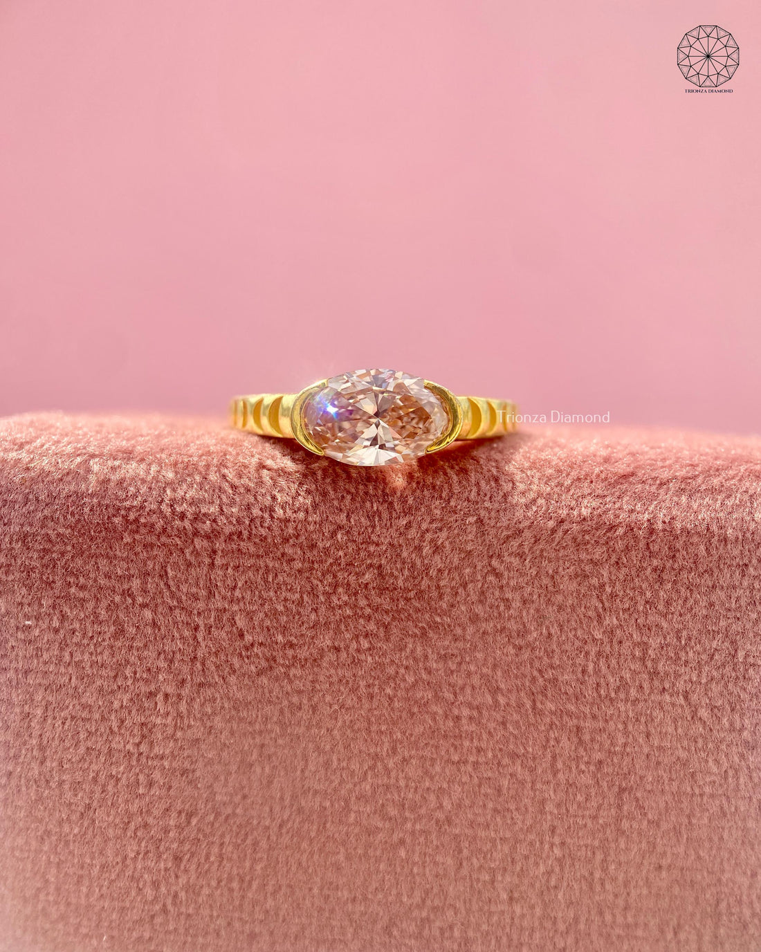 Pink oval lab grown diamond ring with semi-bezel setting in yellow gold fluted band