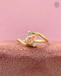 Bypass swirl three stone engagement ring featuring an orange pear cut lab grown diamond center stone
