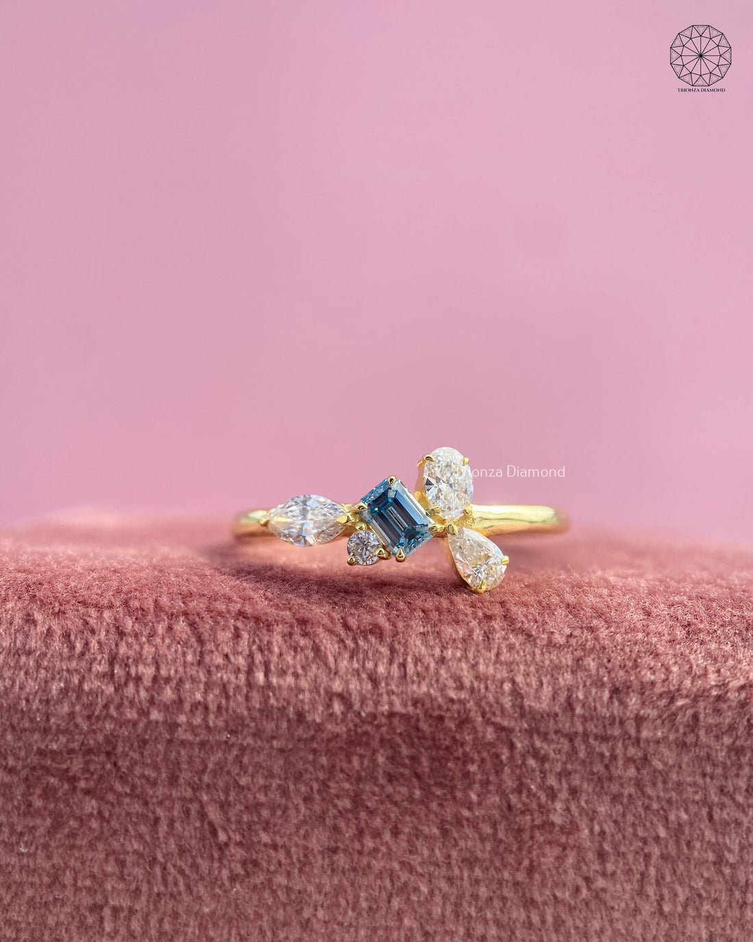 Toi et moi ring with a yellow gold asymmetrical leaf cluster and emerald cut blue stone