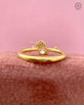 Asymmetrical pear diamond ring displayed to highlight the floral spray accent details