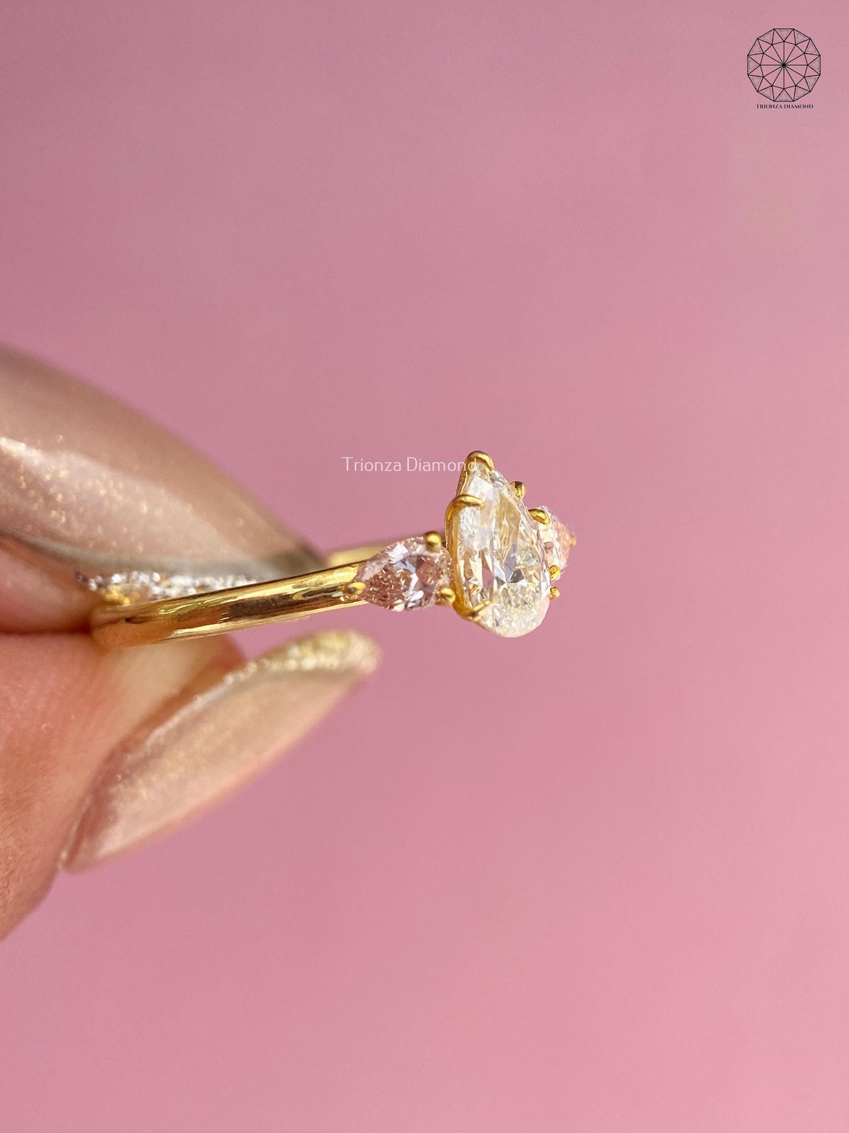 Side view of the minimalist gold band showing the pear diamond arrangement