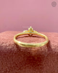 Gold trilogy ring featuring a 0.45 CT pear cut center diamond with pink side stones