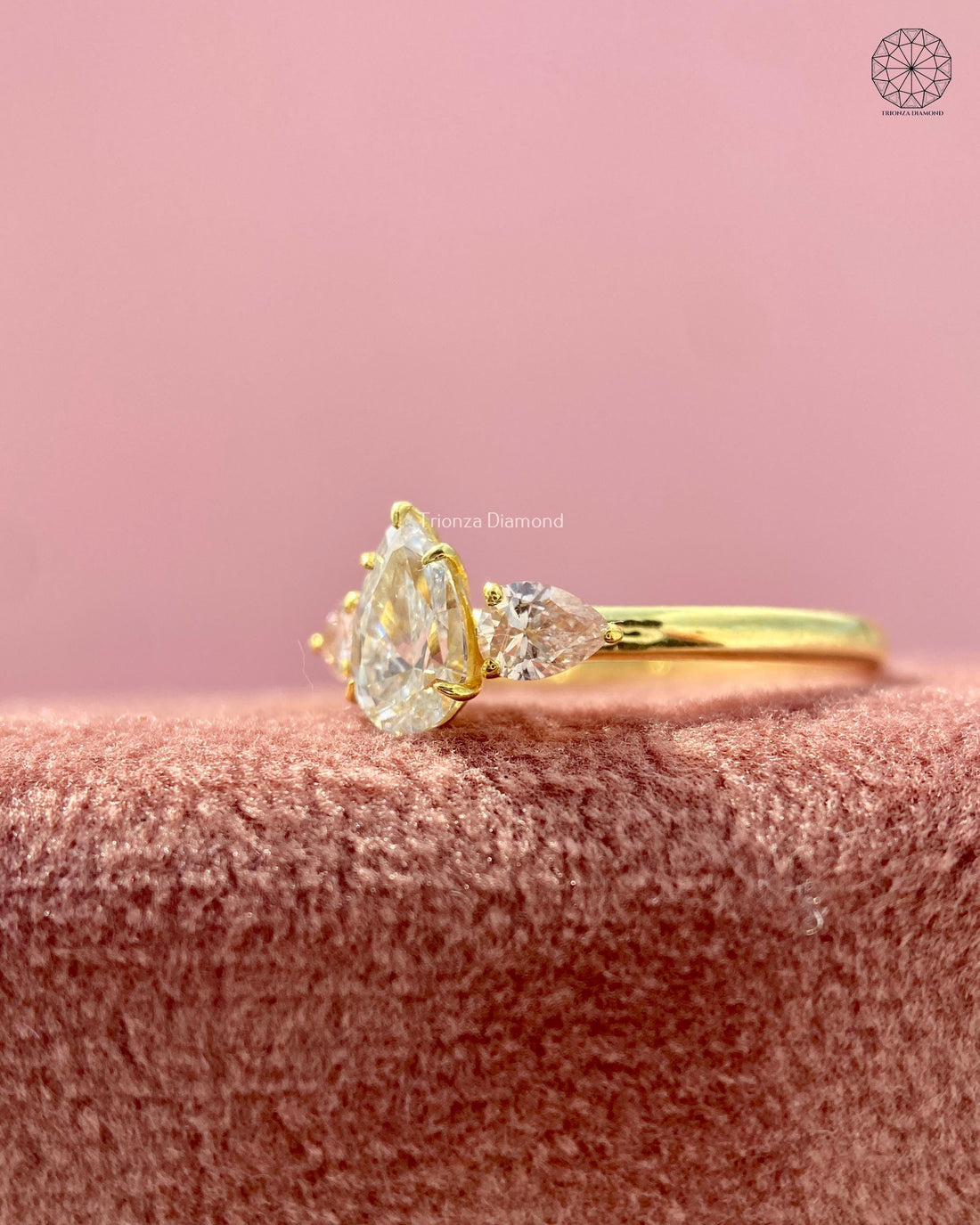 Pear cut lab grown diamond trilogy ring displayed to show its minimalist three stone design