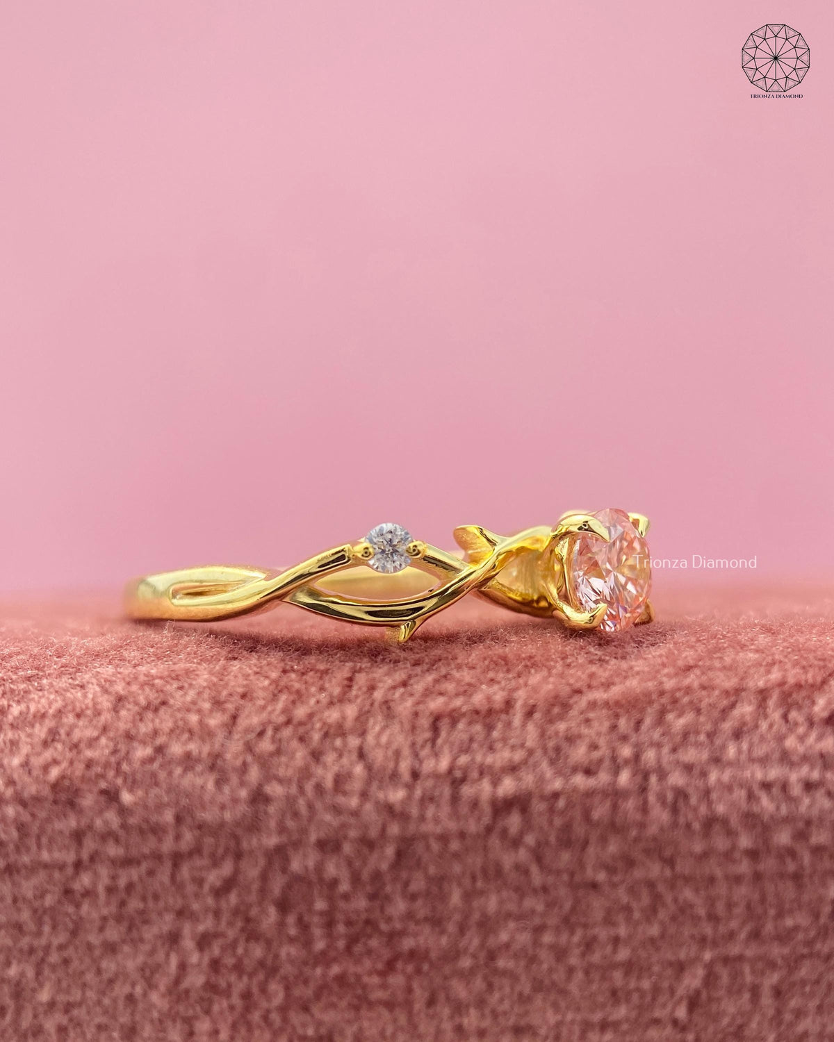 Close-up of the six prong claw setting securing the round brilliant pink diamond solitaire