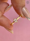 Close-up of the oval brilliant diamond secured in a low profile bezel design
