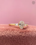 Three stone ring design showcasing the oval brilliant center stone with a slim gold band