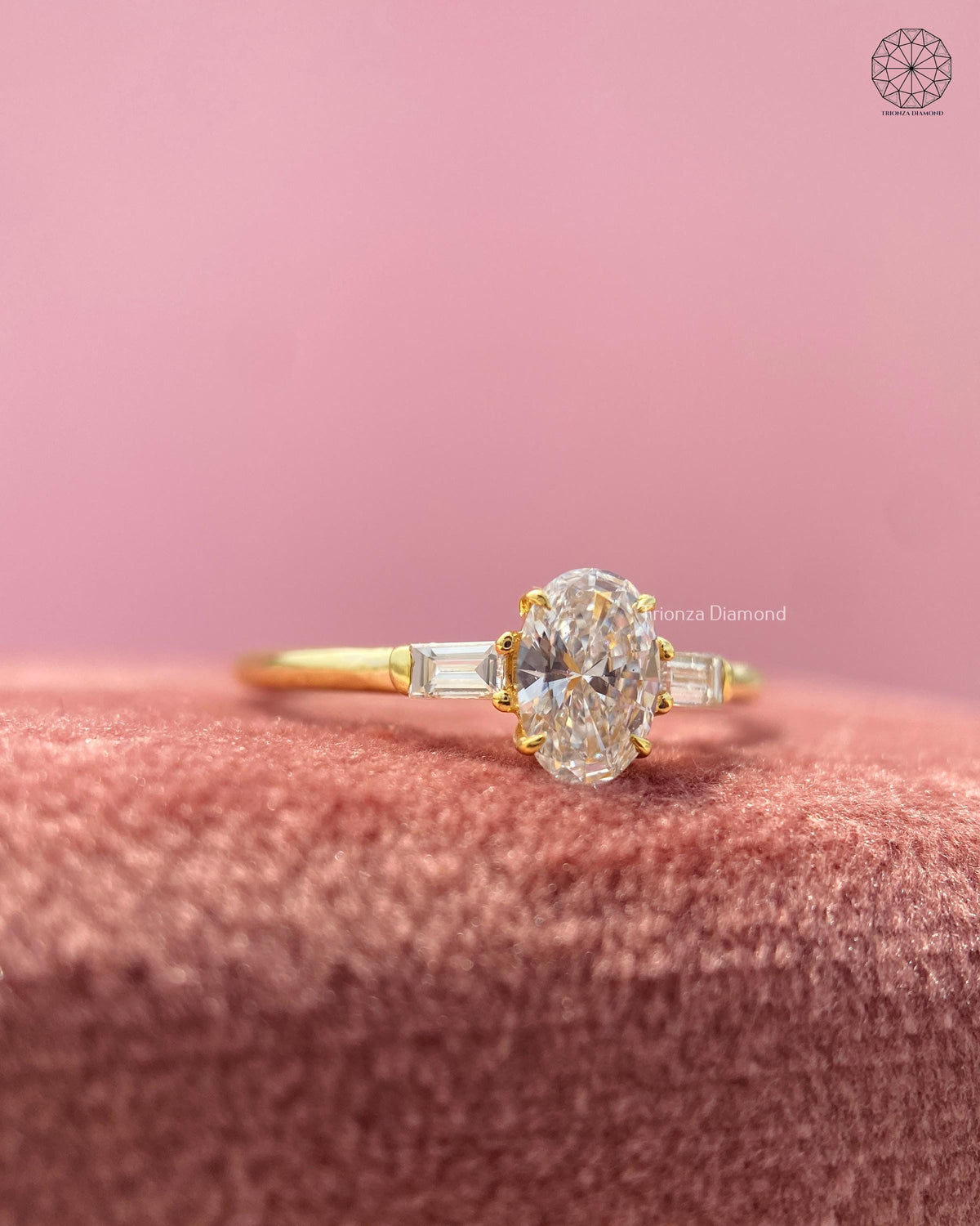 Three stone ring design showcasing the oval brilliant center stone with a slim gold band
