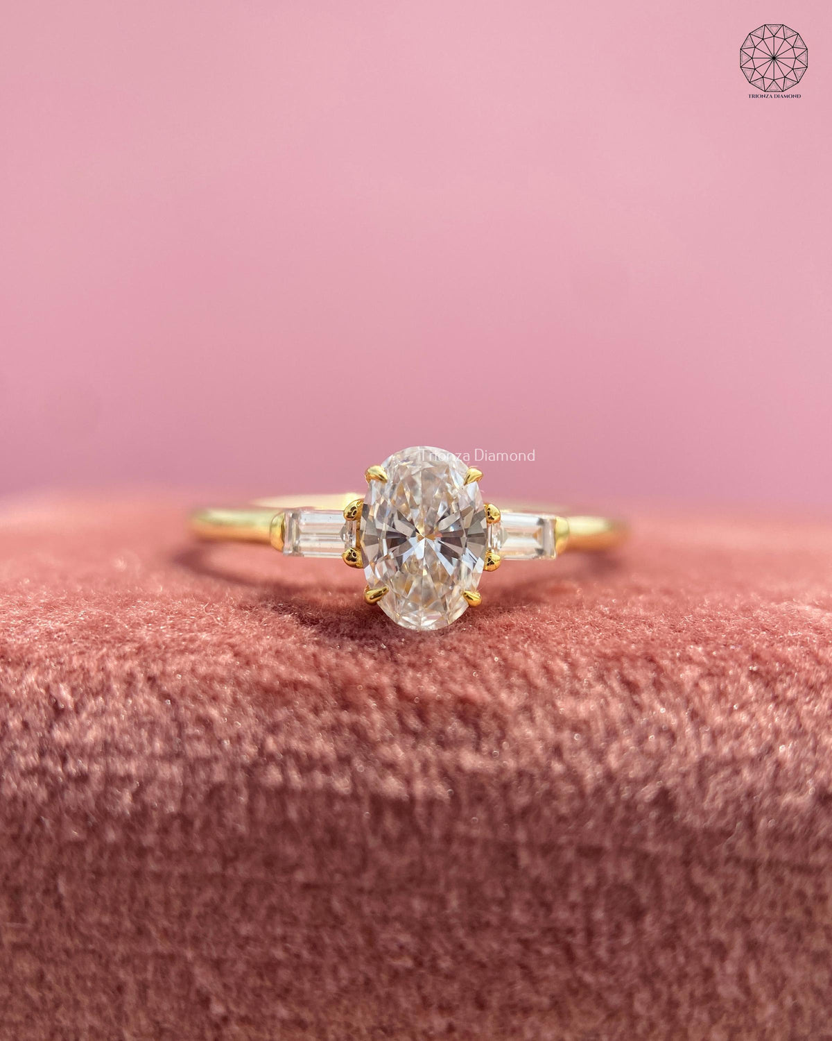 Oval cut lab grown diamond engagement ring featuring tapered baguette side stones in yellow gold