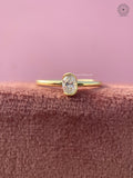 Oval lab grown diamond engagement ring featuring a sleek yellow gold bezel setting