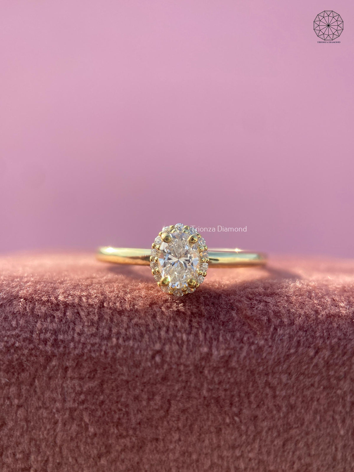 Oval lab grown diamond halo engagement ring displayed in 18K gold with a slim band