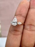 18k gold ring displayed on a stand highlighting the pear cut diamonds